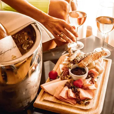a table with a plate of food and a glass of wine at Somewhere Vouliagmeni in Athens
