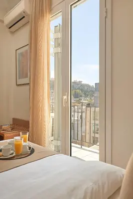 a hotel room with a bed and a large window at Athos Hotel in Athens