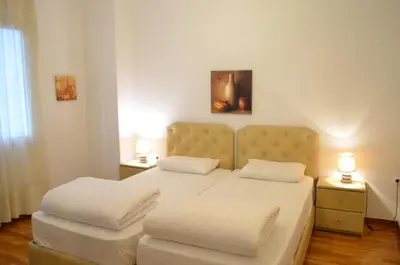 a bedroom with two beds with white sheets and two lamps at Pedion Areos Park 5 Center 5 in Athens