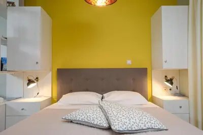 a bedroom with a bed with a yellow wall at Casa D'Irene Apartments in Athens in Athens