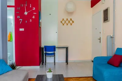 a living room with a red wall with a clock at Travel Resort in Athens