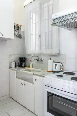 a white kitchen with a stove and a sink at Travel Resort in Athens