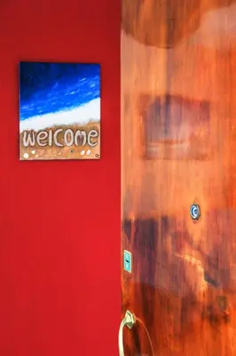 a sign on a red wall with a welcome sign at Travel Resort in Athens