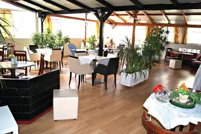 a restaurant with tables and chairs and plants at Diethnes Hotel in Athens