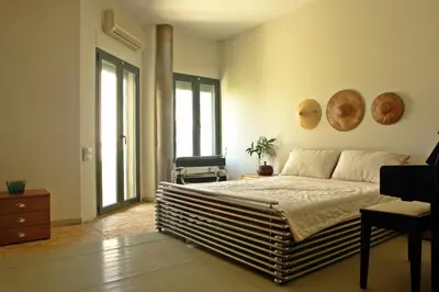 a bedroom with a large bed and large windows at Kallimarmaro Residence in Athens