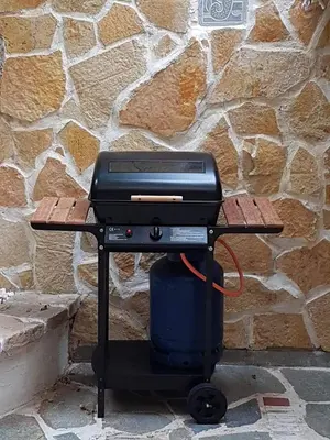 a grill on a table in front of a stone wall at Athens Glyfada Studio in Athens