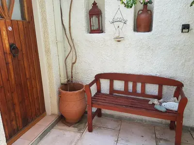 a wooden bench sitting next to a wall with a plant at Athens Glyfada Studio in Athens