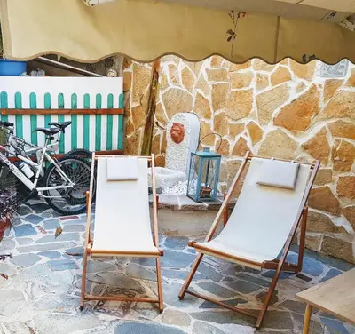 two folding chairs in front of a stone wall at Athens Glyfada Studio in Athens