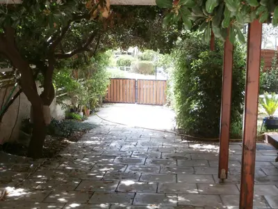 a garden with an arbor and a stone walkway at Athens Glyfada Studio in Athens
