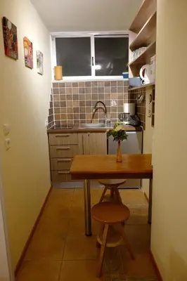 a kitchen with a wooden table and a sink at Athens Glyfada Studio in Athens