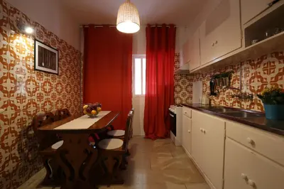 a kitchen with a table and a red curtain at Acropolis Boutique Suite in Athens