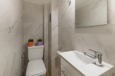 a white bathroom with a toilet and a sink at Acropolis Boutique Suite in Athens
