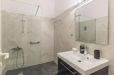 a white bathroom with a shower and a sink at Acropolis Boutique Suite in Athens