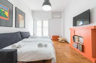 a living room with a bed and a tv at New Relaxed Central Apartment Walk Everywhere in Athens