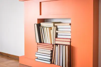 a stack of books on an orange book shelf at New Relaxed Central Apartment Walk Everywhere in Athens