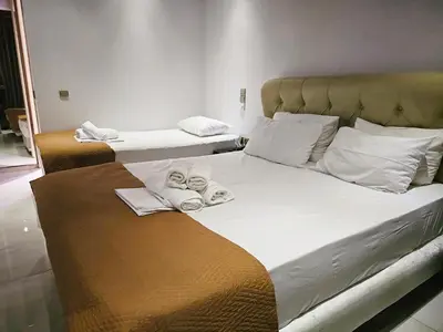 two beds in a room with towels on them at Feevos in Piraeus