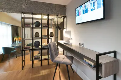 a living room with a desk and a tv on a wall at 47 Luxury Suites in Athens