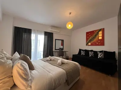 a bedroom with a large bed and a couch at Allure Athens Urban Suites in Athens