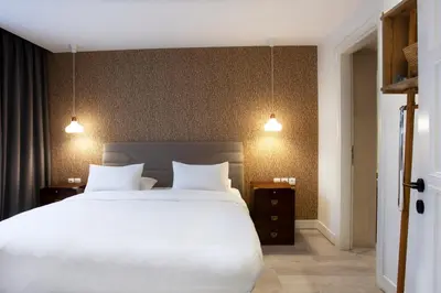 a bedroom with a large white bed and two lights at SV Acropolis Residence in Athens