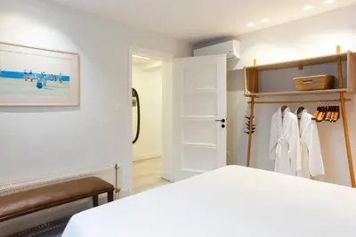 a bedroom with a white bed and a closet at SV Acropolis Residence in Athens