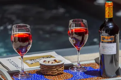 two glasses of red wine next to a bottle of wine at SV Acropolis Residence in Athens