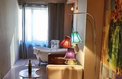 a bathroom with a tub and a table with two lamps at iFeel Athens in Athens