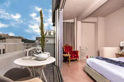 a bedroom with a bed and a table and a view at iFeel Athens in Athens