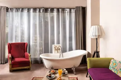 a living room with a tub and a chair at iFeel Athens in Athens