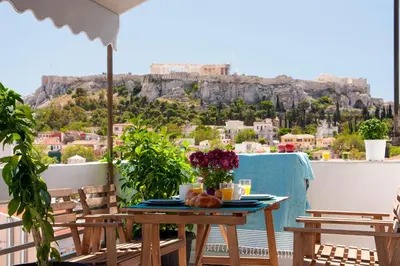 a table on a balcony with a view of the acropolis at Amazing Penthouses with Acropolis View in Athens