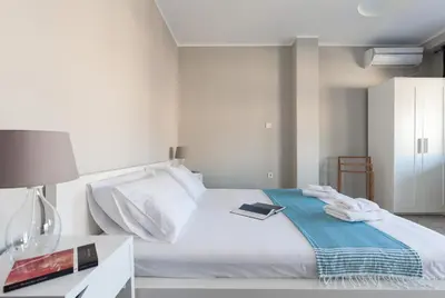 a bedroom with a bed and a table with a book at Amazing Penthouses with Acropolis View in Athens