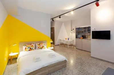 a bedroom with a large bed and a yellow wall at Monastiraki Place in Athens