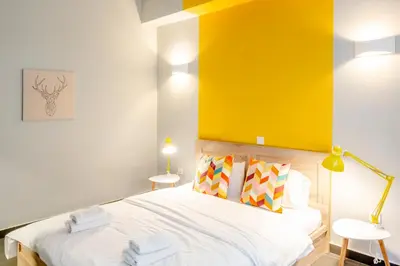 a bedroom with a bed with a yellow wall at Monastiraki Place in Athens