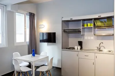 a small kitchen with a white table and chairs at Monastiraki Place in Athens