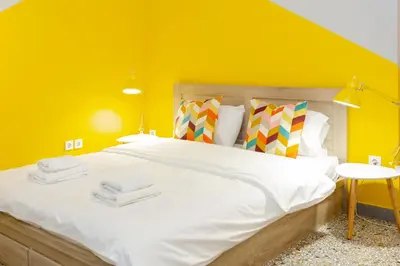 a bedroom with a large bed with yellow walls at Monastiraki Place in Athens