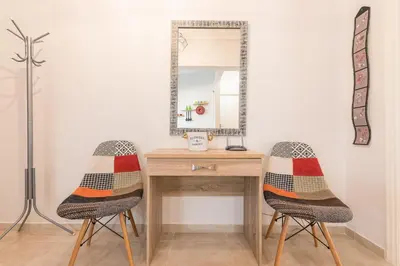two chairs sitting next to a wooden desk with a mirror at Zenios Ippokratis-Comfort & style, Athens downtown in Athens