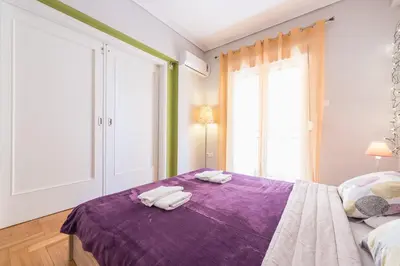 a bedroom with two towels on a purple bed at Zenios Ippokratis-Comfort & style, Athens downtown in Athens