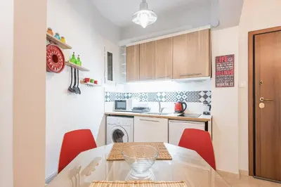 a small kitchen with a table and red chairs at Zenios Ippokratis-Comfort & style, Athens downtown in Athens