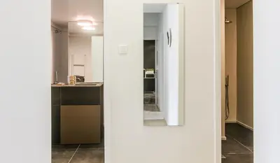 a white kitchen with a sink and a mirror at ABA Apartment 2 Vourvachi street in Athens