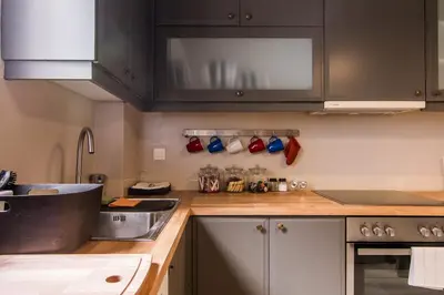 a kitchen with black cabinets and a counter top at ABA Apartment 2 Vourvachi street in Athens