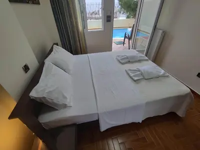a bedroom with a bed with white sheets and pillows at Private pool & Panorama View on Athens center Hill in Athens