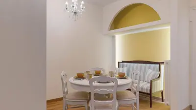 a dining room with a table with chairs and a chandelier at The Koukaki Residence in Athens