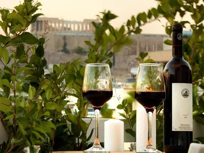 two glasses of red wine next to a bottle of wine at Athens View Loft - 01 in Athens