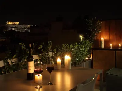 a table with two glasses of wine and two candles at Athens View Loft - 01 in Athens