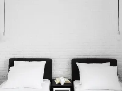 two beds with white pillows in front of a wall at Athens View Loft - 01 in Athens