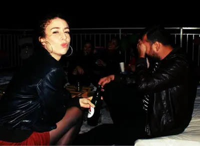 a woman sitting next to a man holding a beer at Acropolis View Dream in Athens