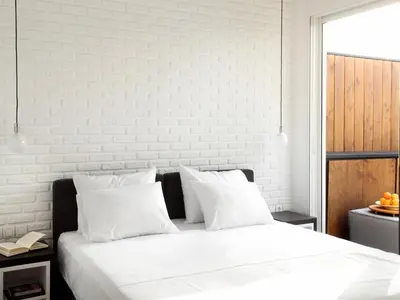 a white bedroom with a large bed with white pillows at Athens View Loft - 02 in Athens