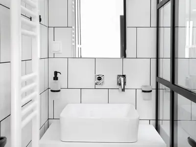 a white bathroom with a sink and a window at Athens View Loft - 02 in Athens