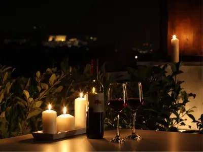 a bottle of wine and a glass on a table with candles at Athens View Loft - 05 in Athens