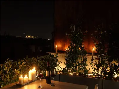 a table with candles and lights on a balcony at night at Athens View Loft - 05 in Athens