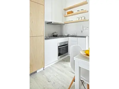 a kitchen with white cabinets and a white table at Athens View Loft - 06 in Athens